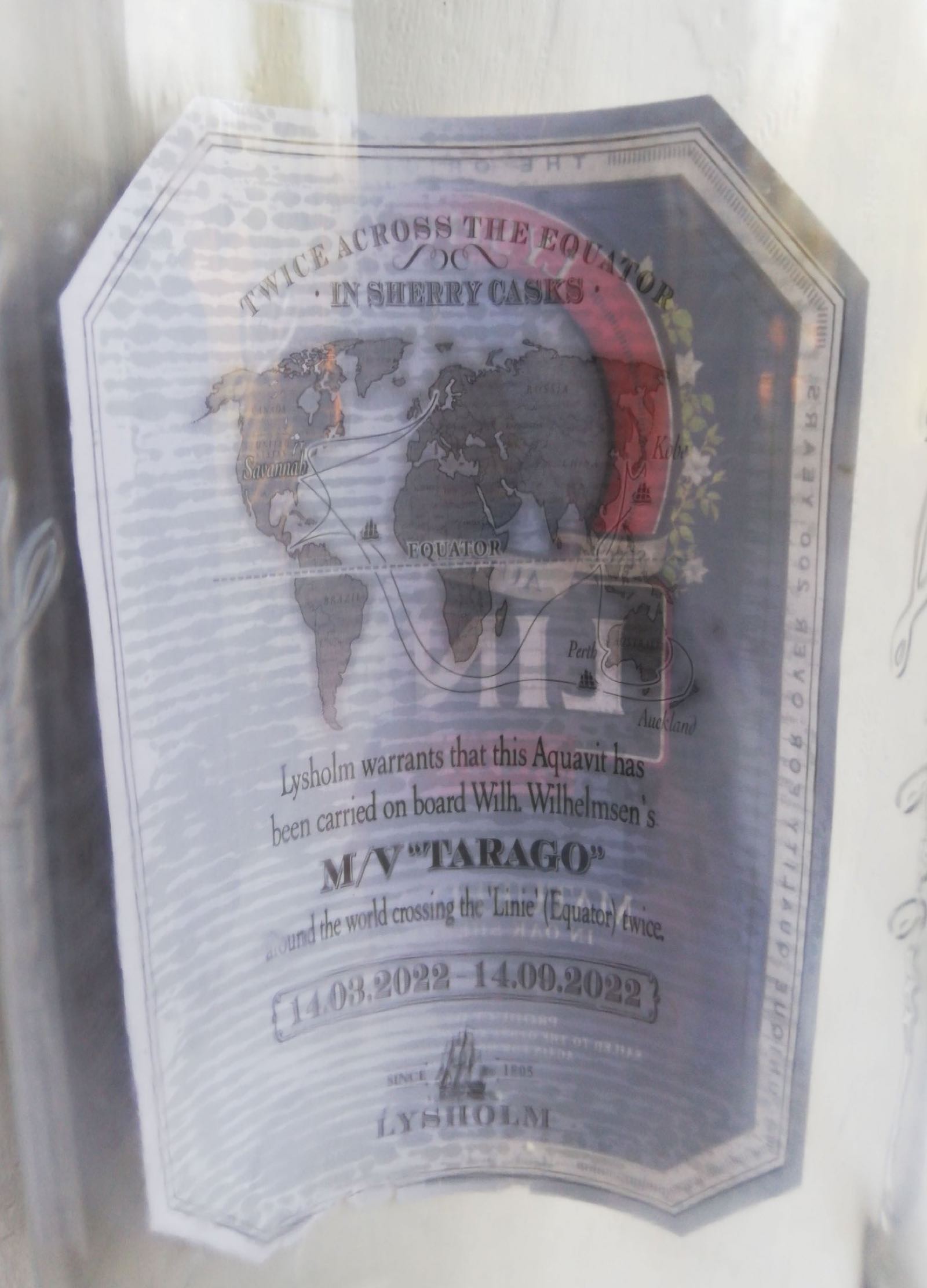 Обратная сторона этикетки Linie Aquavit: карта мира, маршрут, имя судна и две даты